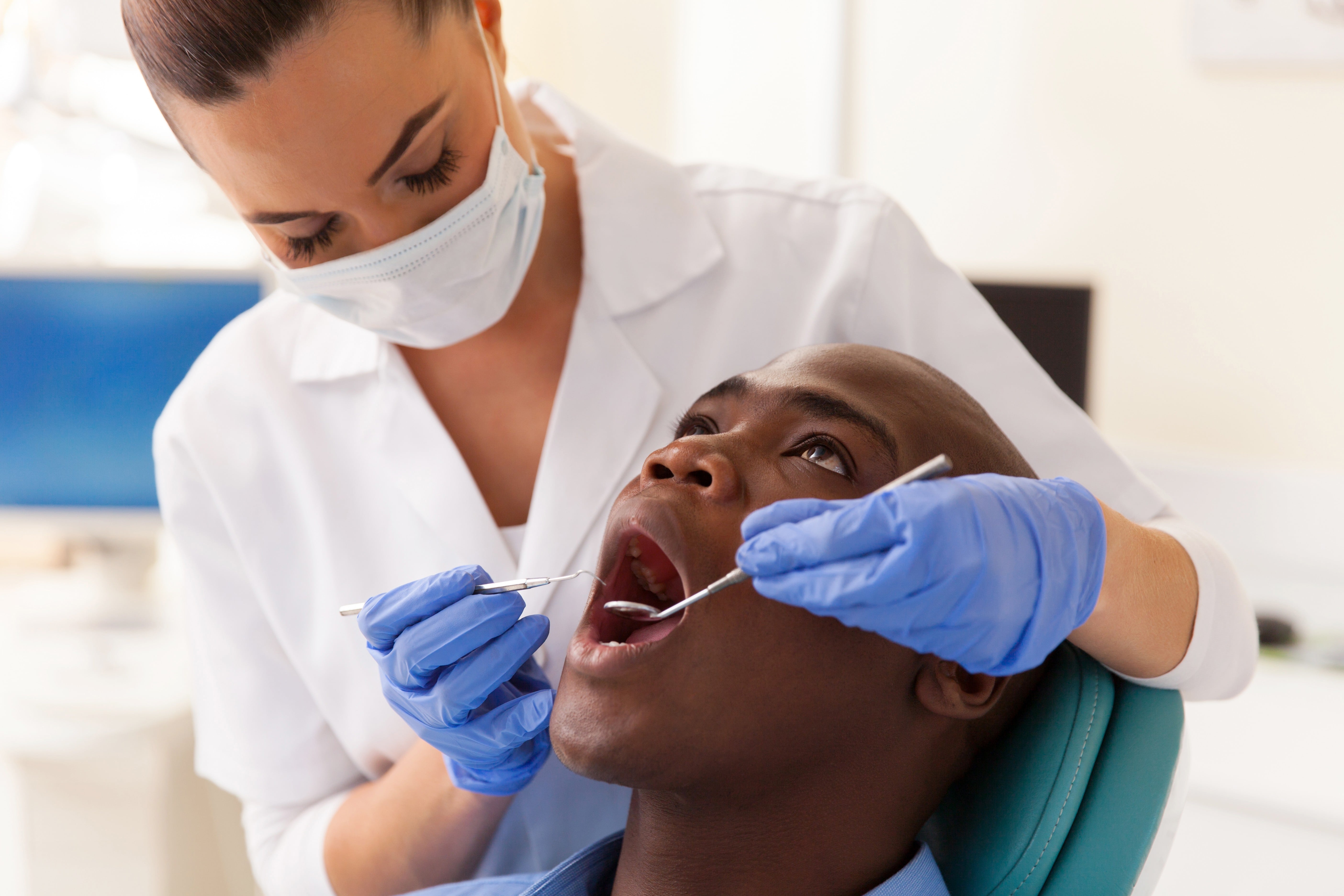 Dentist Examining Male Patient